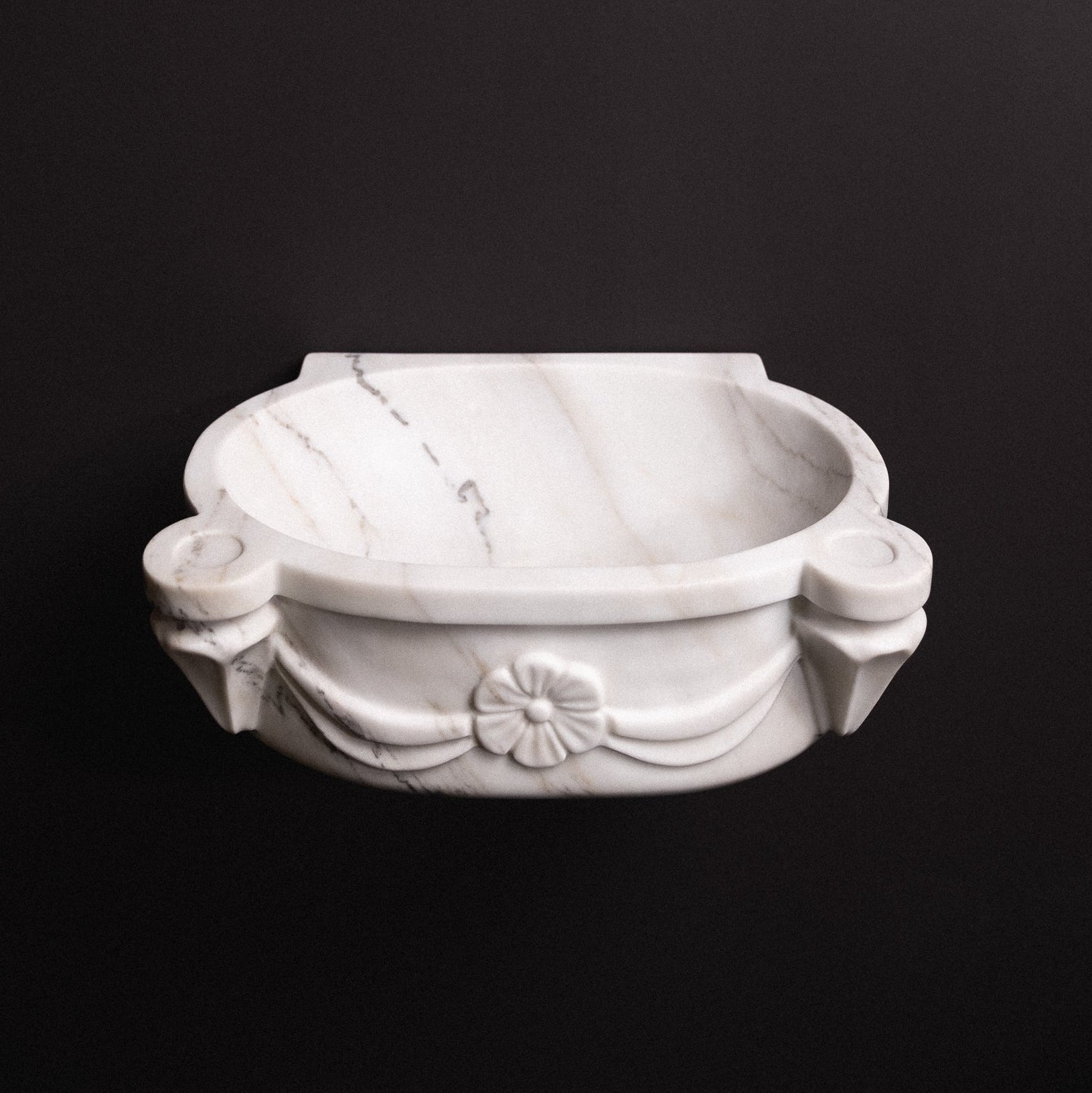 White marble wall-mounted sink with floral rosette carvings and draped detailing — luxury hand-carved marble basin for bathrooms.