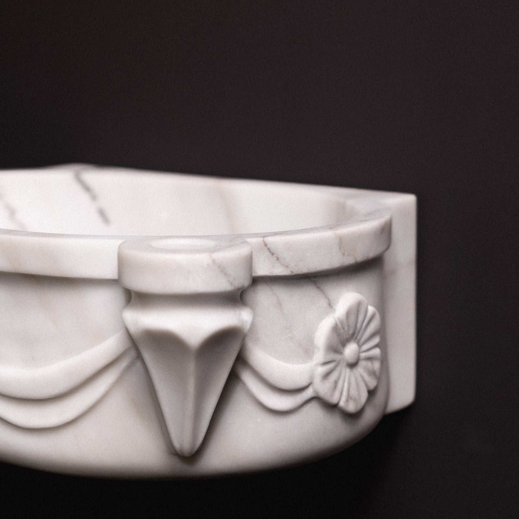 White marble floating wall-mounted sink with floral rosette carvings and draped detailing — luxury hand-carved marble basin for bathrooms.