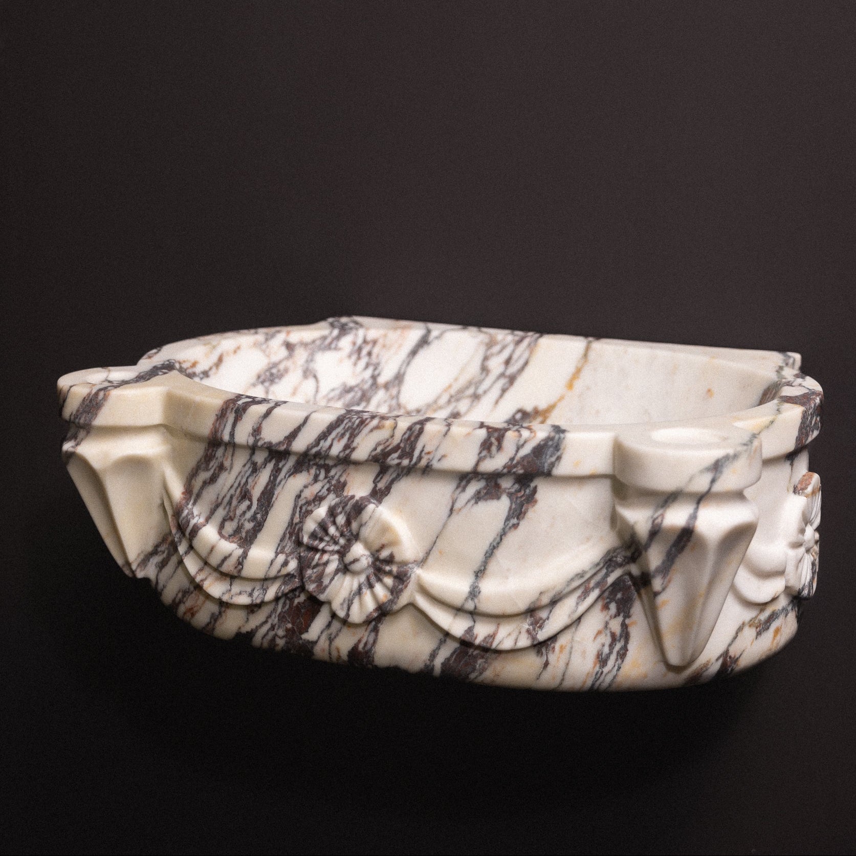 Calacatta viola marble floating wall-mounted sink with floral rosette carvings and draped detailing — luxury hand-carved marble basin for bathrooms.