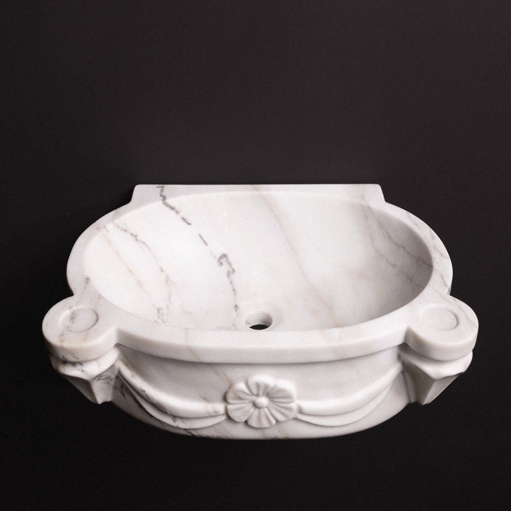 White marble wall-mounted sink with floral rosette carvings and draped detailing — luxury hand-carved marble basin for bathrooms.