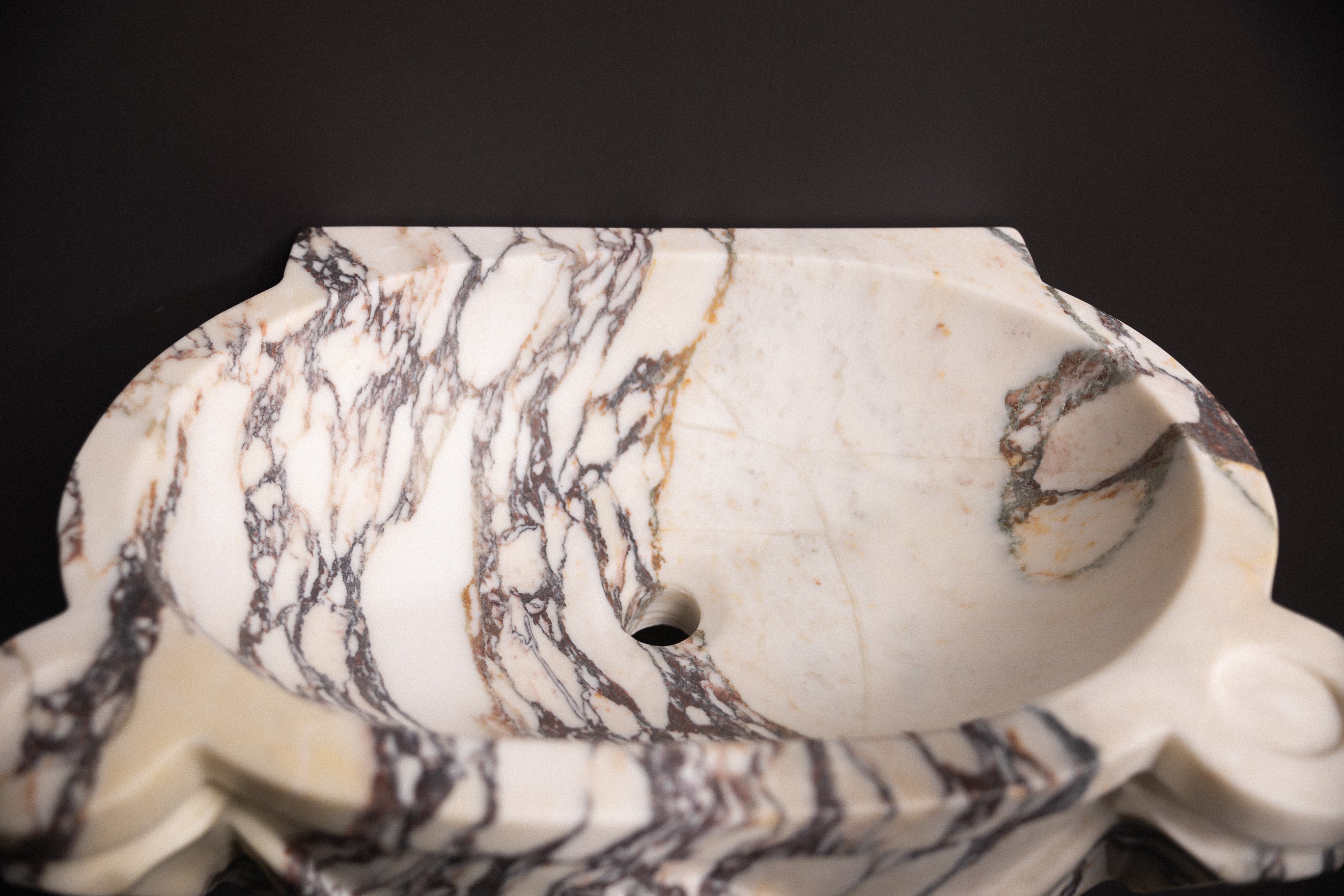 Calacatta viola marble floating wall-mounted sink with floral rosette carvings and draped detailing — luxury hand-carved marble basin for bathrooms.